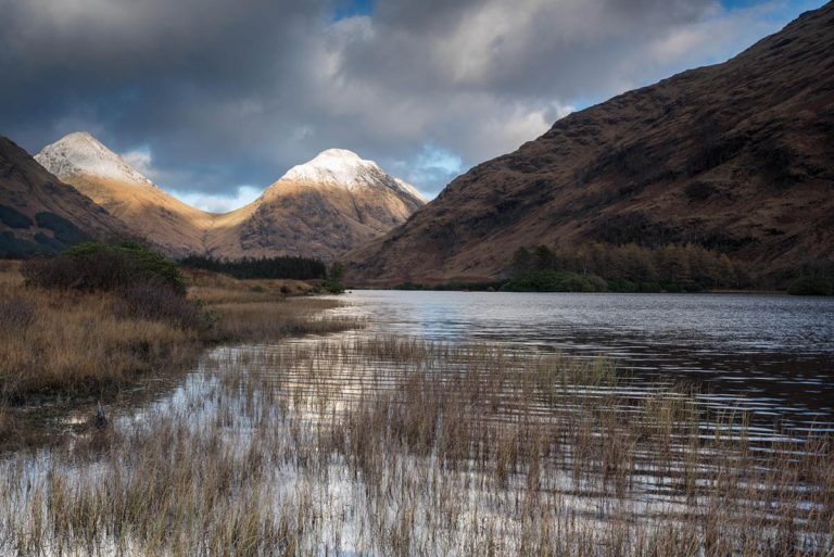Sunlight catches the mountains at Lochan Urr, Glen Etive, Scotland, UK